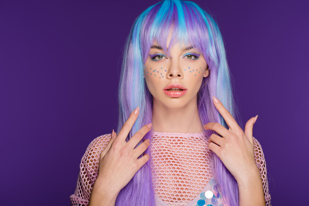 atraktivní dívka pózuje v fialovou paruku s hvězdami na obličeji, izolované na fialová - Fotografie, Obrázek