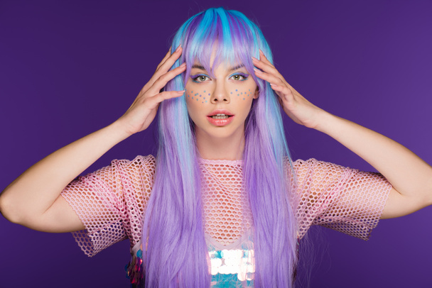 pretty girl posing in violet wig with stars on face, isolated on purple - Photo, Image