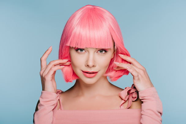 attractive stylish girl gesturing and posing in pink wig isolated on blue - Fotoğraf, Görsel