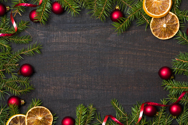 Σκοτεινό ρουστίκ ξύλινος πίνακας flatlay - χριστουγεννιάτικο φόντο με διακόσμηση και έλατα υποκατάστημα καρέ. Το Top view με ελεύθερο χώρο για αντιγραφή κειμένου - Φωτογραφία, εικόνα