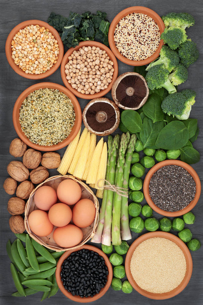 Υγιείς υψηλής περιεκτικότητας σε πρωτεΐνη τρόφιμα με φρέσκα λαχανικά, όσπρια, γαλακτοκομικά, δημητριακά, σπόρους και ξηρούς καρπούς. Σούπερ τρόφιμα με υψηλή περιεκτικότητα σε φυτικές ίνες, βιταμίνες και αντιοξειδωτικά. Το Top view. - Φωτογραφία, εικόνα