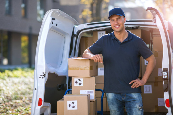 Delivery man standing in front of his van - Foto, Imagen