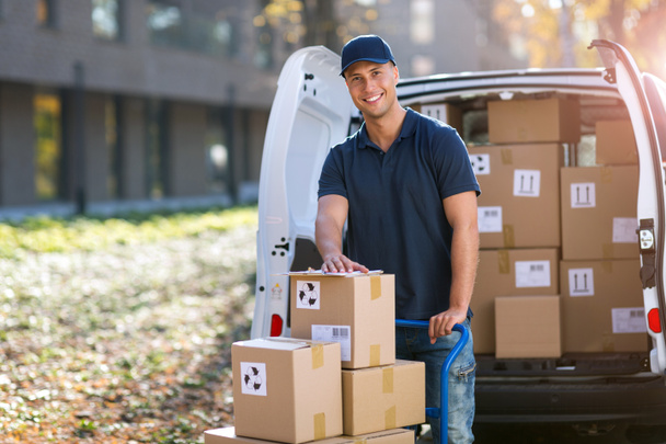 Delivery man standing in front of his van - Foto, afbeelding