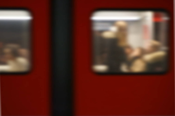 Tren de pasajeros con desenfoque de movimiento / La vista lateral del cuerpo de un tren de pasajeros con contornos borrosos de viajeros en las ventanas del tren
 - Foto, Imagen