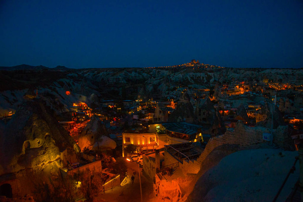Illuminated at night streets of Goreme, Turkey, Cappadocia. On the horizon - Uchisar. Amazing night landscape. - Fotó, kép