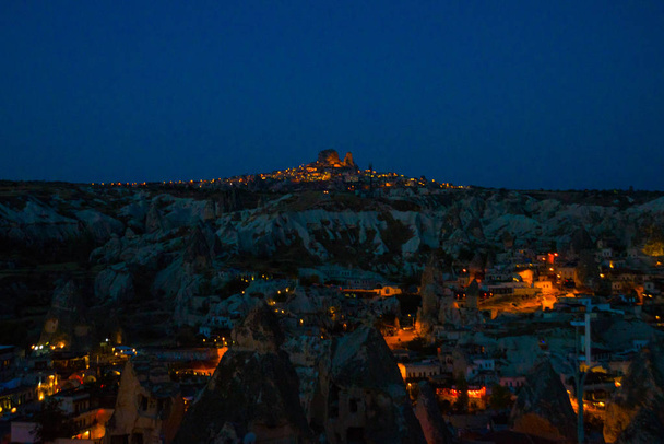 Illuminated at night streets of Goreme, Turkey, Cappadocia. On the horizon - Uchisar. Amazing night landscape. - Φωτογραφία, εικόνα