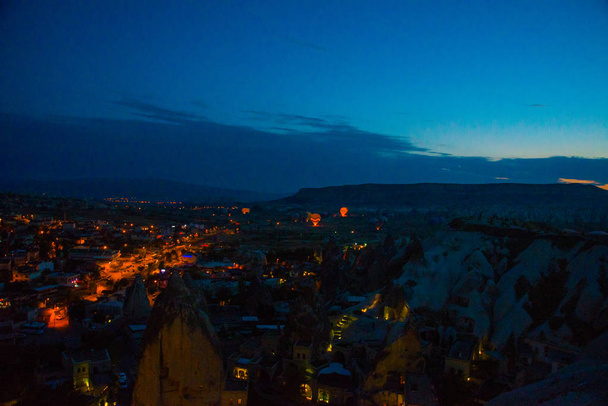 Illuminated at night streets of Goreme, Turkey, Cappadocia. The famous center of flight balloons. Amazing night landscape. - Фото, изображение