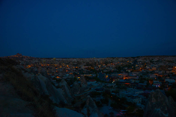 Illuminated at night streets of Goreme, Turkey, Cappadocia. The famous center of flight balloons. Amazing night landscape. - Фото, изображение