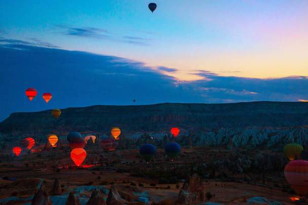 Cappadocia, Goreme, Anatolia, Turkey. Hot Air balloons flying over Mountains landscape sunset Cappadocia. Favorite entertainment for tourists. - Foto, afbeelding