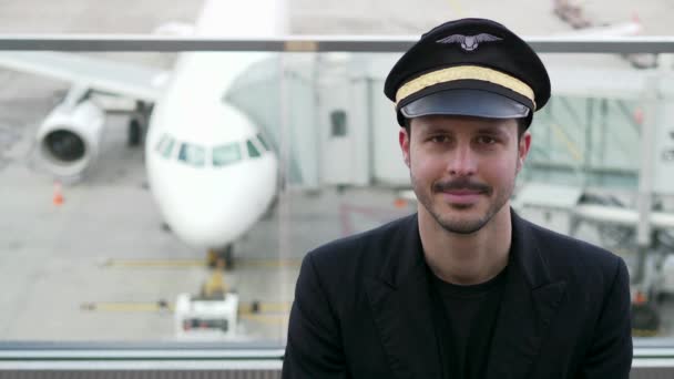Fiatal férfi pilóta pózol a repülőtéren - Felvétel, videó