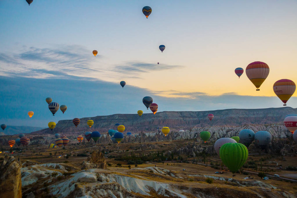 Hot air balloons over mountain landscape in Cappadocia, Goreme National Park, Turkey, Anatolia. Favorite entertainment for tourists. - Foto, imagen