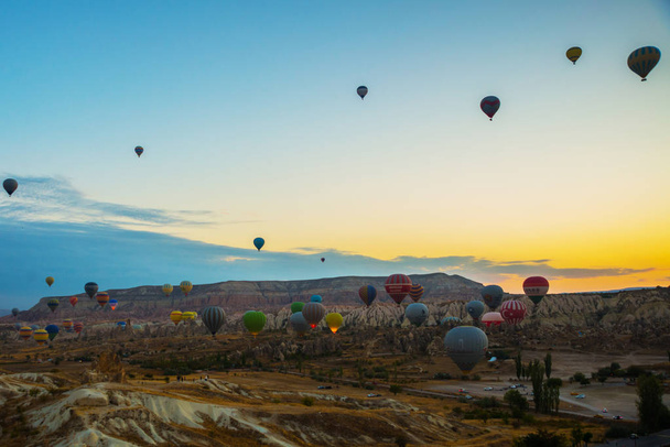 Goreme, Turkey. Numerous hot air balloons all lift into the air just after dawn. Popular entertainment for tourists - Fotoğraf, Görsel
