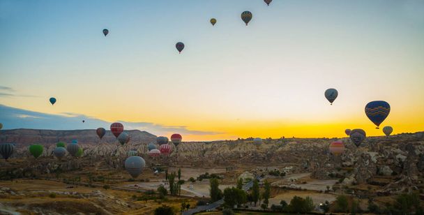 Goreme, Turkey. Numerous hot air balloons all lift into the air just after dawn. Popular entertainment for tourists - Фото, изображение
