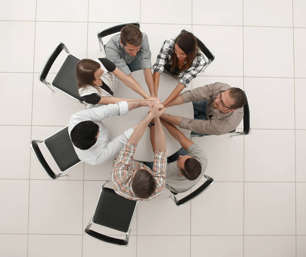top view.the smiling business team folded their hands together - Фото, зображення