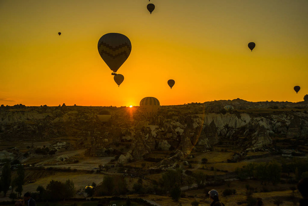 Silhouette of hot air balloons flying over the valley at Cappadocia, Anatolia, Turkey. Volcanic mountains in Goreme national park. Favorite entertainment for tourists. - Фото, зображення