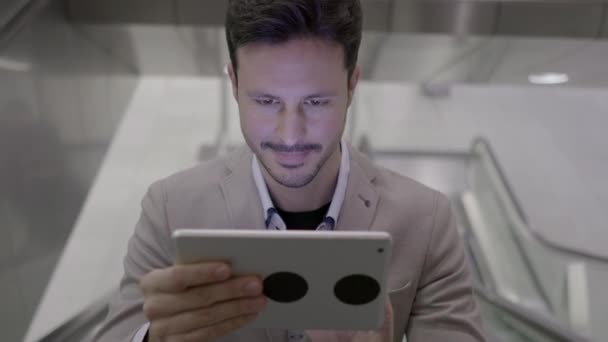 Young caucasian man is using tablet PC on elevator - Video, Çekim