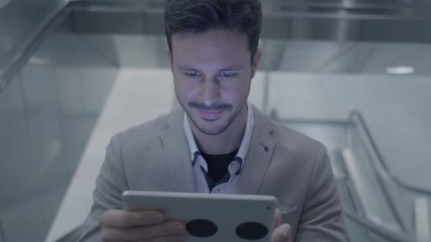 Young caucasian man is using tablet PC on elevator - Séquence, vidéo