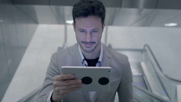 Young caucasian man is using tablet PC on elevator - Video