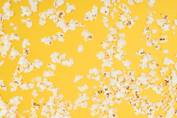vista superior de palomitas dispersas crujientes aisladas en amarillo
 - Foto, Imagen