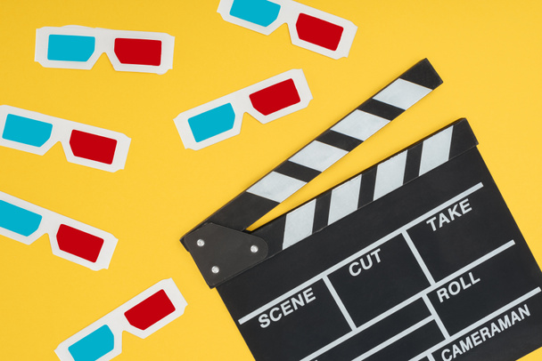 plastic 3d glasses and clapperboard isolated on yellow - Photo, Image