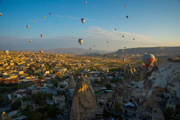 The view from the observation deck of Goreme in Sunny weather: rock the house, the hills and hot air balloon. Turkey, Cappadocia, Anatolia. - Photo, Image