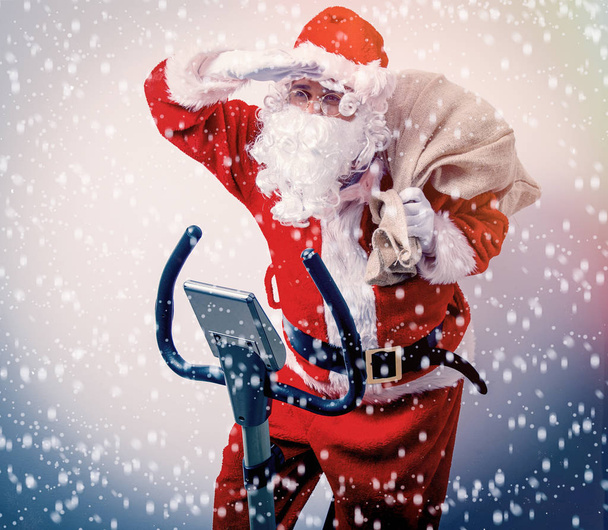 Zábavné Santa Claus bavit s rotopedy na bílém pozadí - Fotografie, Obrázek