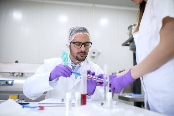 primer plano de dos científicos que verifican la calidad de los productos cosméticos en el laboratorio
 - Foto, Imagen