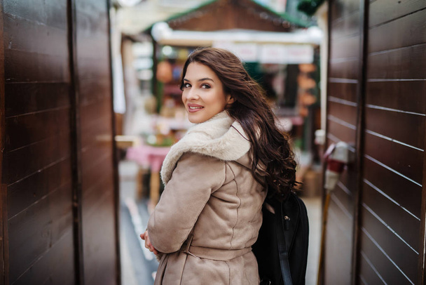 Beautiful Caucasian woman dressed in coat looking over the shoulder. - Photo, Image