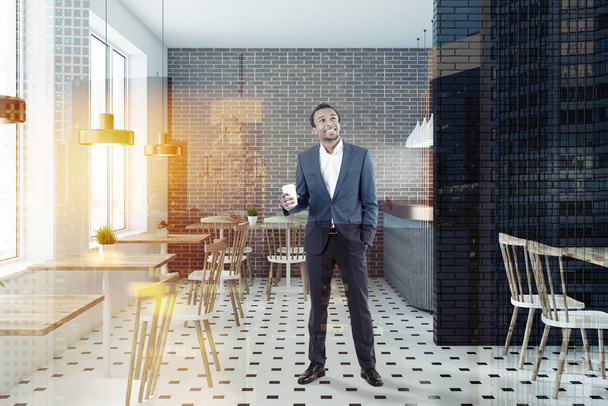African American businessman in brick and black brick restaurant interior with tiled floor, gray bar and wooden tables with white and wooden chairs. Toned image double exposure - Photo, Image