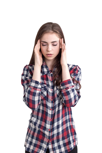 Isolated portrait of beautiful young woman with long fair hair wearing checkered shirt having a headache. Concept of stress and overworking - Фото, изображение