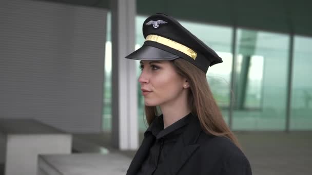 Beautiful female pilot is walking in airport  - Video