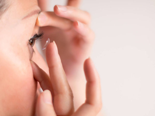 Крупным планом изображение женщины, надевающей контактные линзы на глаз; выборочная фокусировка
. - Фото, изображение