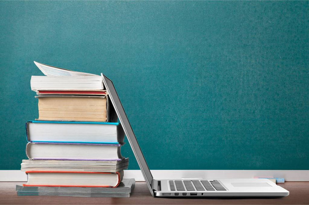 Stack of books and laptop, education and learning background - Фото, изображение