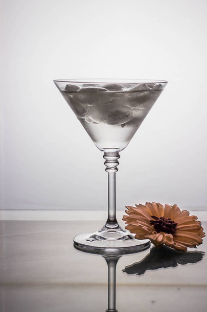 cocktail glass with drink on a light background with reflection on a mirrored table - Photo, Image