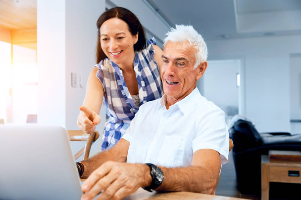 Ευτυχισμένος μοντέρνο ζευγάρι εργάζεται σε φορητό υπολογιστή στο σπίτι - Φωτογραφία, εικόνα