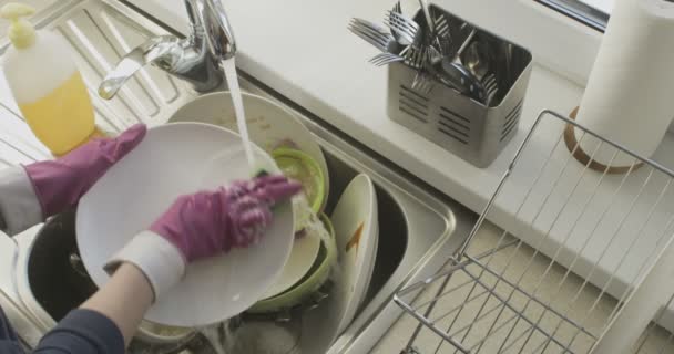 Stapel vuil vaatwerk handen wassen in de keukengootsteen in slow motion - Video