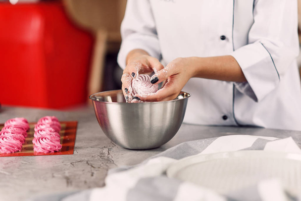 Szef kuchni przygotowuje delikatne domowe marshmallows z jej rąk. Pojęcie gotowanie w domu. - Zdjęcie, obraz