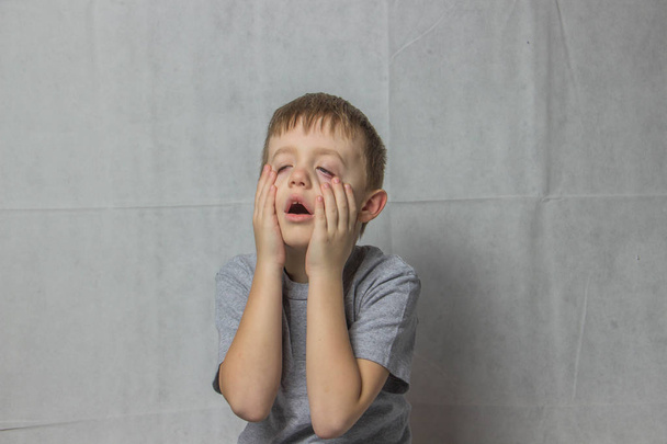 Rahatsızlık şaşkınlık içinde gri bir T-shirt çocukta - Fotoğraf, Görsel