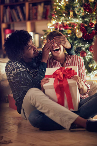 romantic surprise for Christmas holiday  young male and female with present - 写真・画像