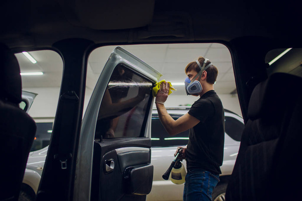 Handsome man cleaning car with hot steam - Fotó, kép