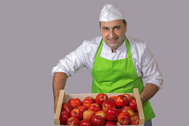 Vendedor de fruta con una caja de manzanas rojas
 - Foto, Imagen