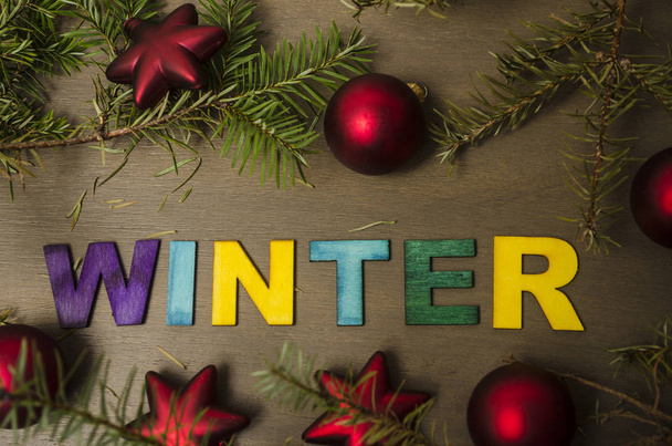 Composizione per le vacanze invernali con rami e palline rosse di Natale e stelle. Disegno lettering invernale
 - Foto, immagini