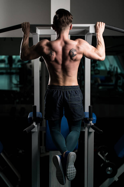 Handsome Bodybuilder Doing Heavy Weight Exercise For Back On Machine - Fotografie, Obrázek