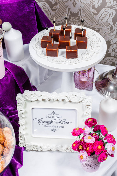 Candy bar. Wedding reception table with sweets, candies, dessert, meringues, fruit tart, cupcakes, muffins, cakes, eclairs - Photo, Image