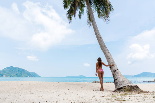 Young slim woman near palm on a white tropical beach - Фото, зображення