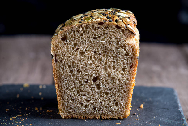 Свежеиспеченный здоровый хлеб на старом деревянном фоне. Цельнозерновой хлеб
. - Фото, изображение