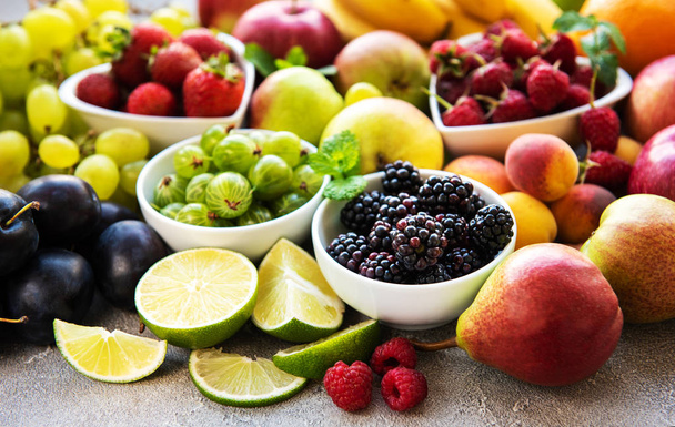 Fresh summer fruits and berries on a concrete background - Photo, image