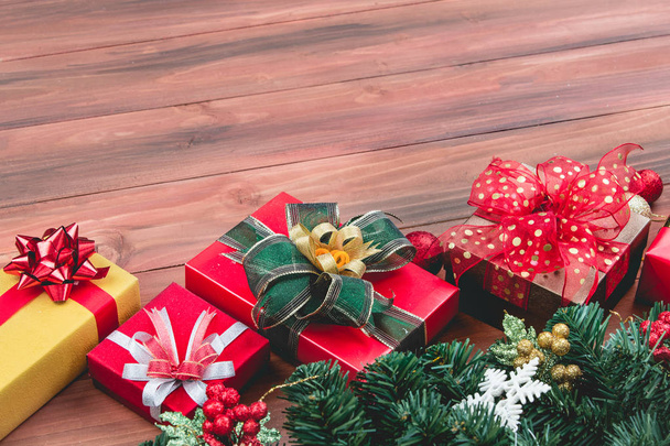 Scatole regalo di festa in linea su tavola di legno, decorare con rami di pino e ornamenti natalizi. Copia dello spazio nell'area bottem
. - Foto, immagini
