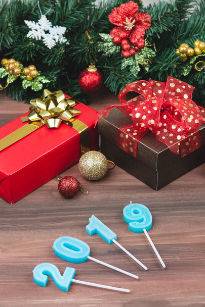 Capodanno festive candele blu anno 2019 forma, messa a fuoco morbida di una scatola regalo rossa, disposizione verticale. L'avvento di un nuovo concetto di anno migliore
. - Foto, immagini