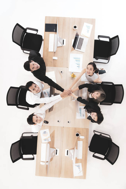 Professional business analysis team put hands together as teamwork symbol and looking up high, background of computers working  desk, top view. - Photo, Image